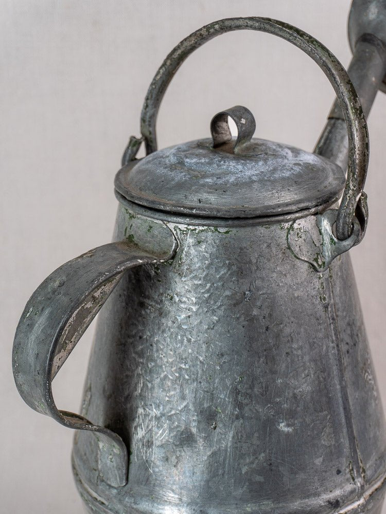 Antique French zinc watering can in milk can shape, early 20th century, with lid, curved handle, spout, and visible patina.
