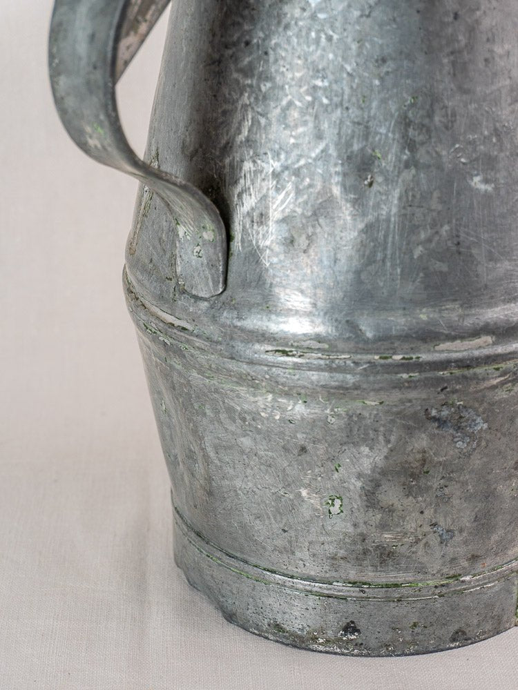 Antique French zinc watering can with milk can silhouette, early 20th century, scratches and discoloration visible.