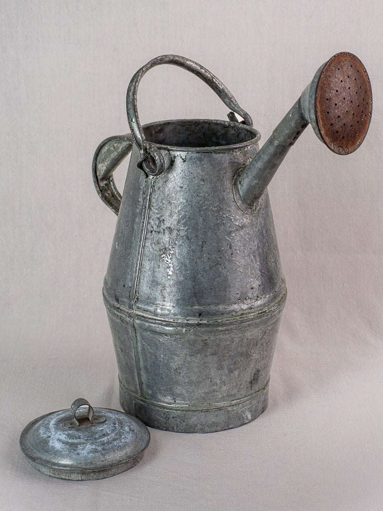 Antique French zinc watering can, milk can shape, round handle, removed lid, rust-toned perforated spout.