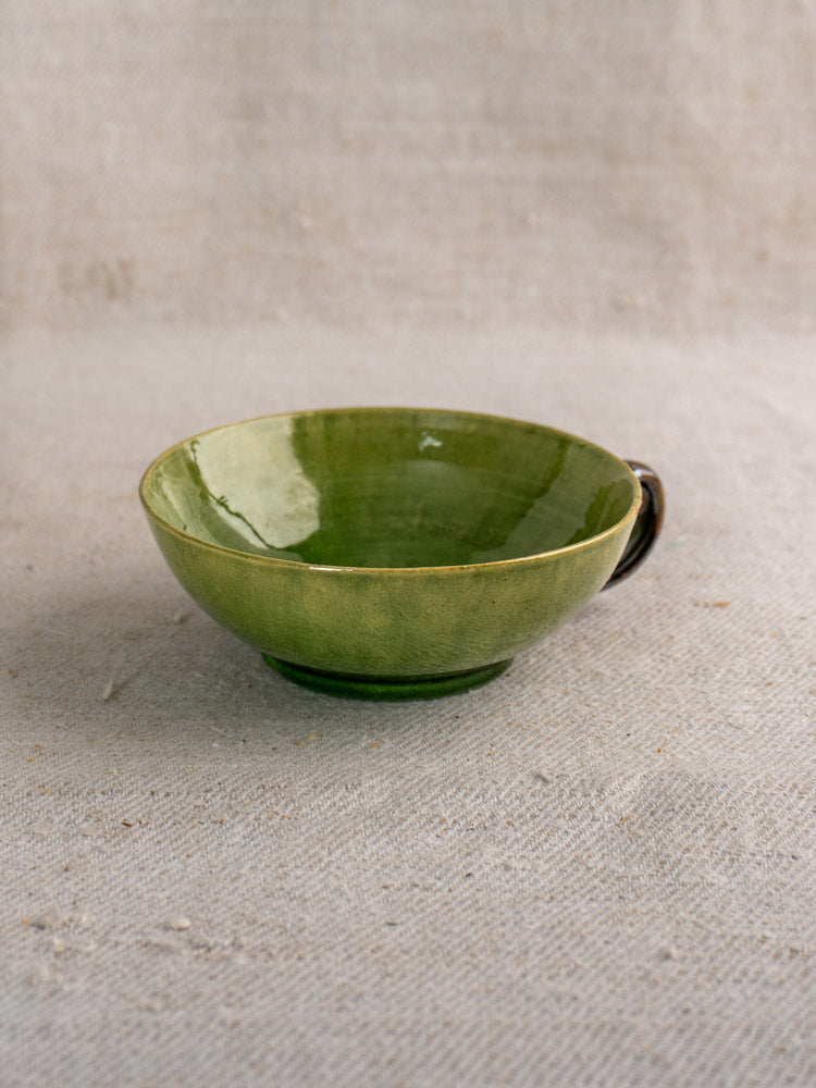 Set of six vintage French teacups with Dieulefit green glaze on textured linen background.