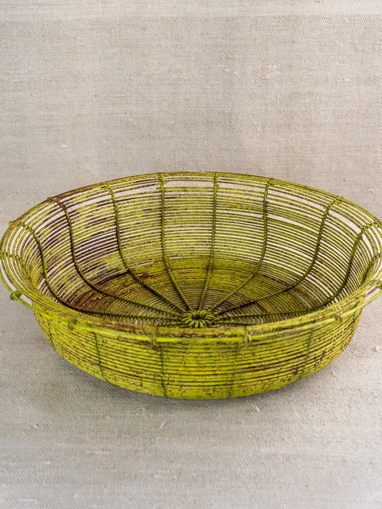 Antique French wire basket from the Green Painted Fil de Fer set, circa 1900, on beige fabric.