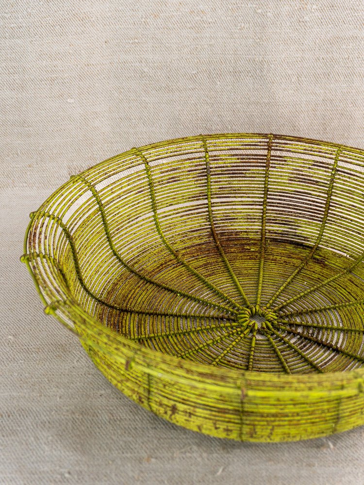 Antique French wire basket, circa 1900, green fil de fer with aged patina on beige fabric.