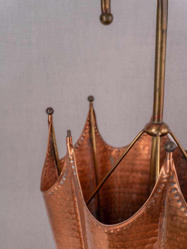 Vintage French hammered copper umbrella stand with brass handle and pegs, mid-century crown rim design.
