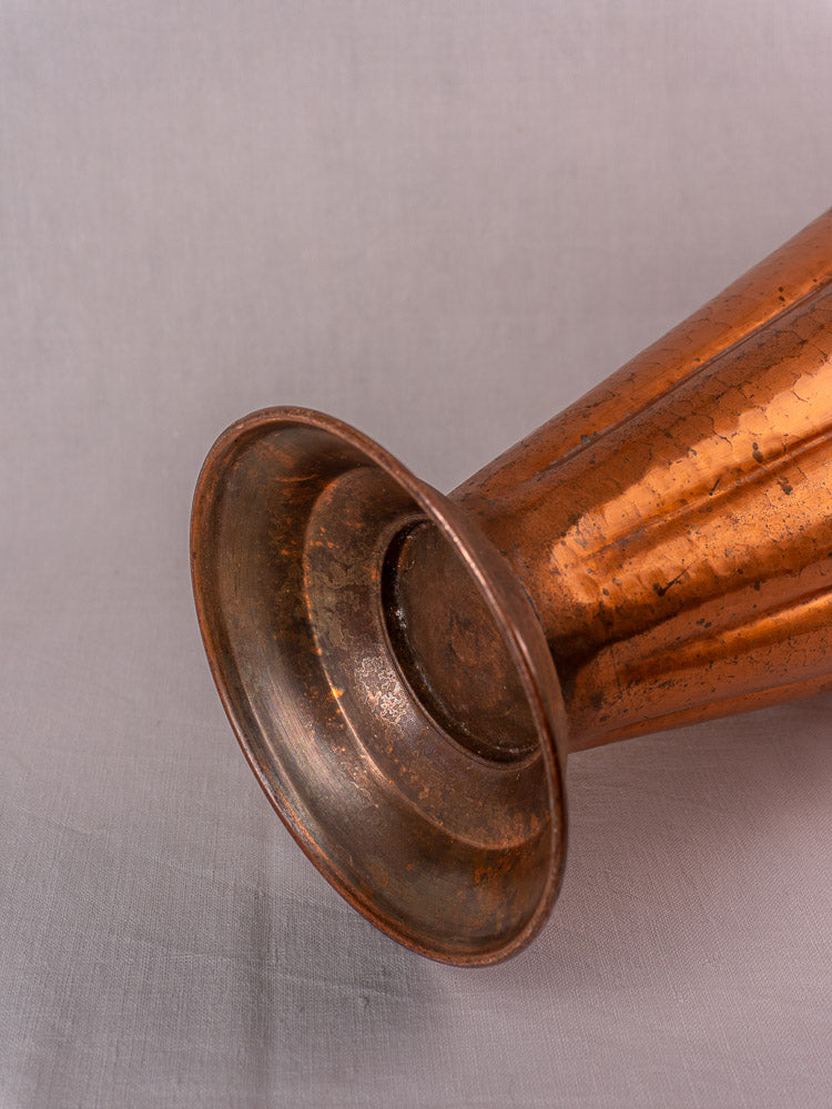 Vintage French umbrella stand in hammered copper and brass, mid-century style, on light gray fabric.