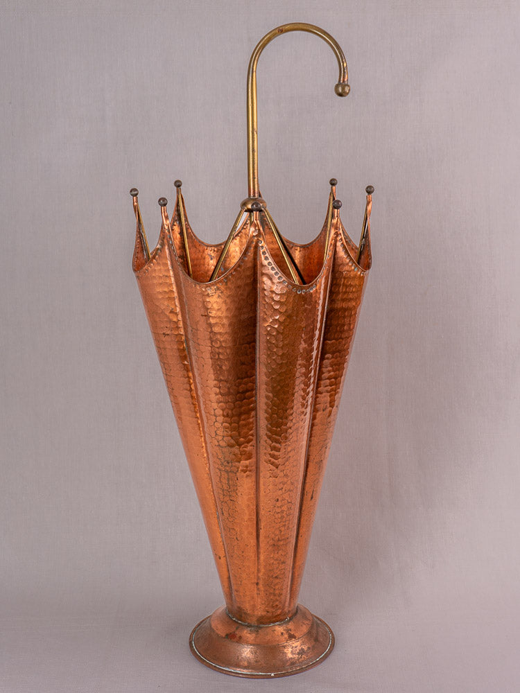 Mid-century French umbrella stand in hammered copper with flared top and curved brass handle.