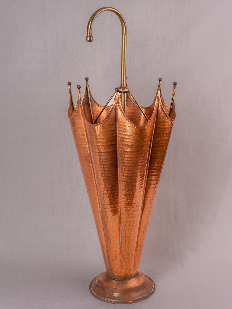Mid-century French umbrella stand with hammered copper body and brass handle, shown against plain background.