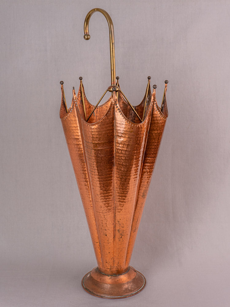 Vintage French hammered copper umbrella stand with brass accents and gold curved handle, mid-century style.