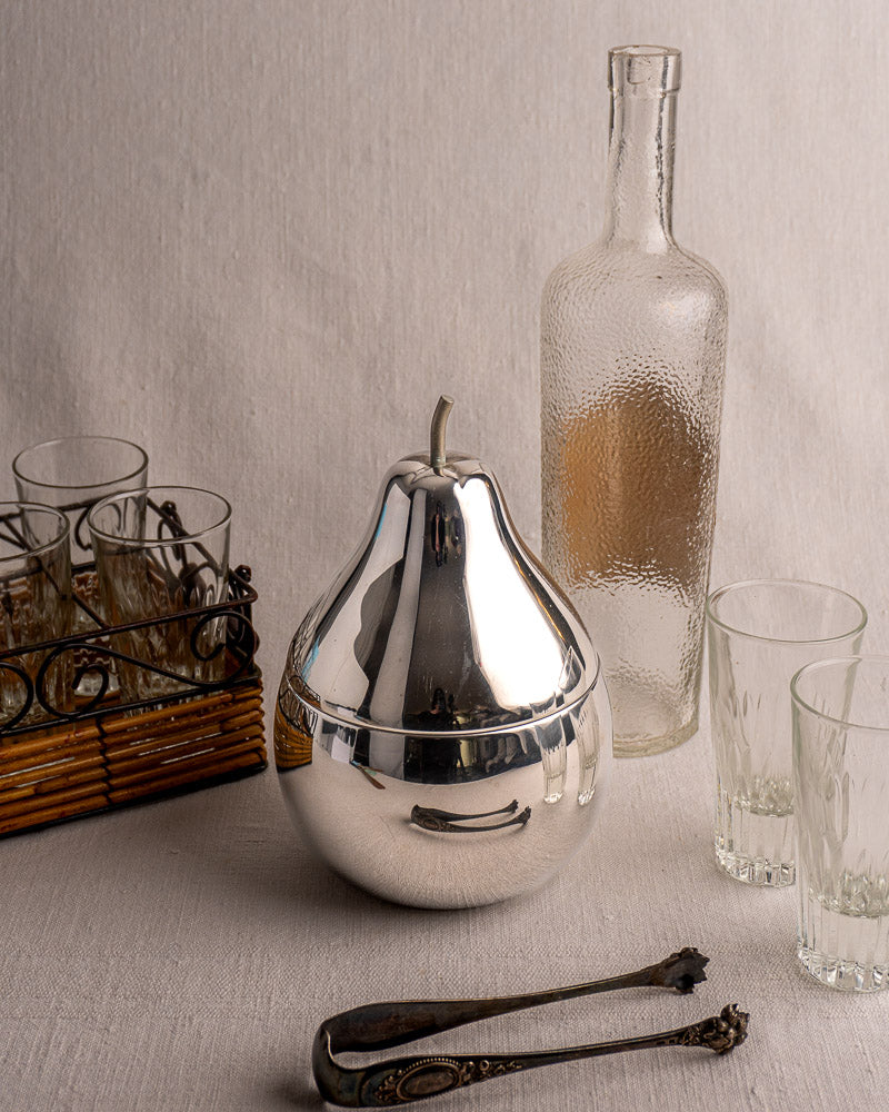 Vintage French stainless steel pear ice bucket with removable lid, mid-century barware on pale surface.