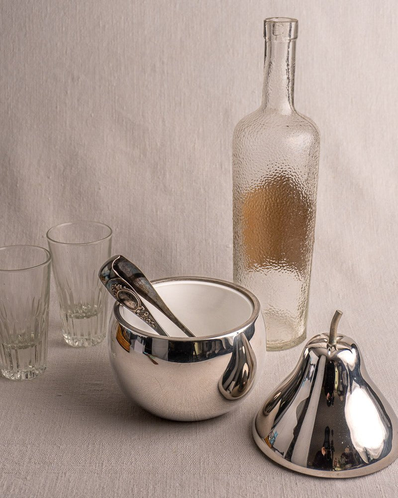 Vintage French pear-shaped stainless steel ice bucket from the 1960s with two glasses on fabric.