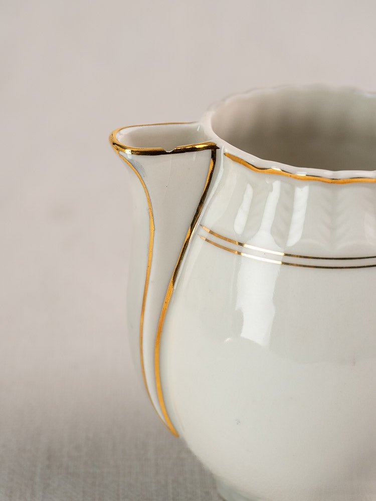 White Bernardaud porcelain creamer with gold trim and scalloped rim from French Limoges tea service.