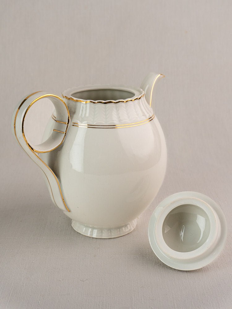 Antique French Limoges Bernardaud tea set, white porcelain with gold trim, teapot and lid displayed.