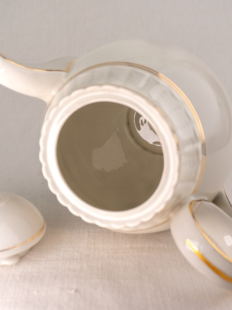 White Bernardaud porcelain teapot with gold trim, lid off, antique French Limoges tea service.
