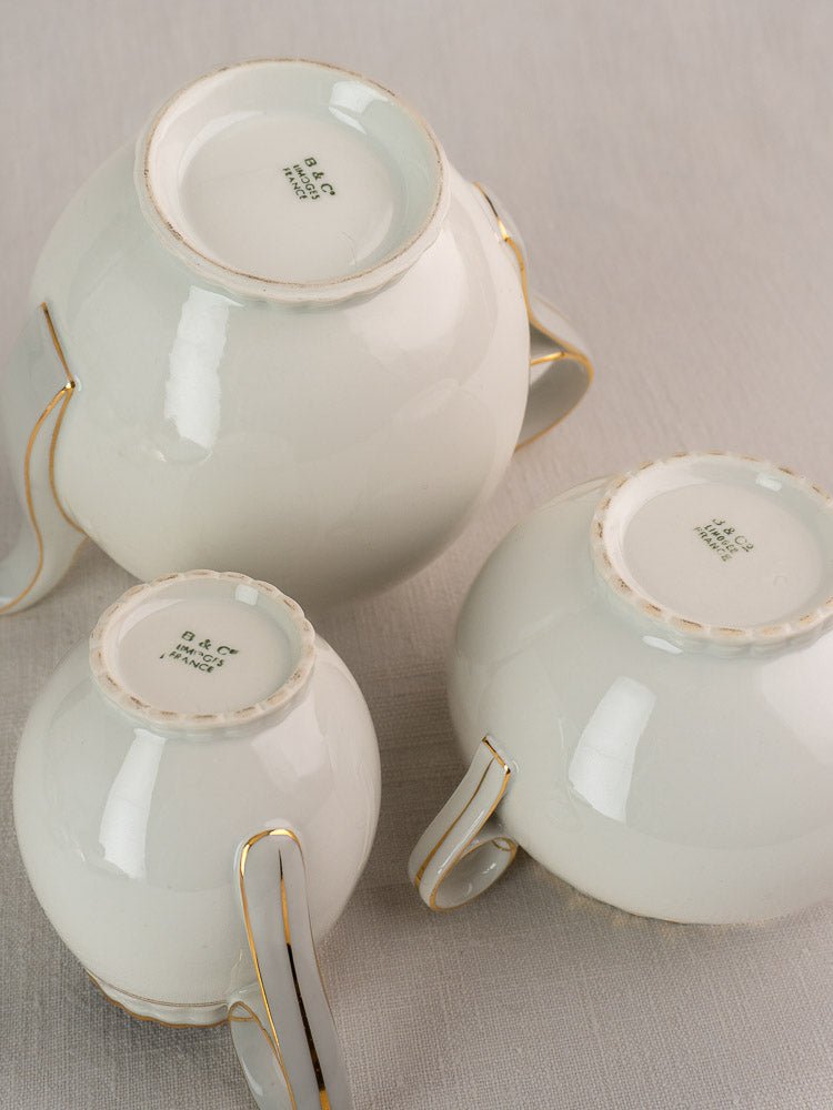 Set of three gold-trimmed antique French Limoges Bernardaud teacups, D & C France mark visible.