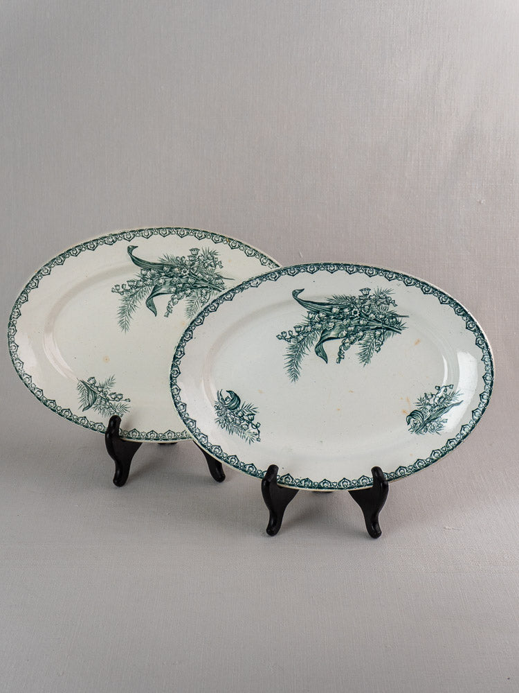 Set of five antique French Saint Amand Muguet faience oval platters with green floral motifs.