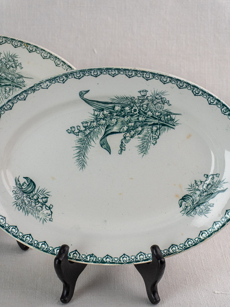 Antique French Saint Amand Muguet faience platter set with green floral and cornucopia motifs.