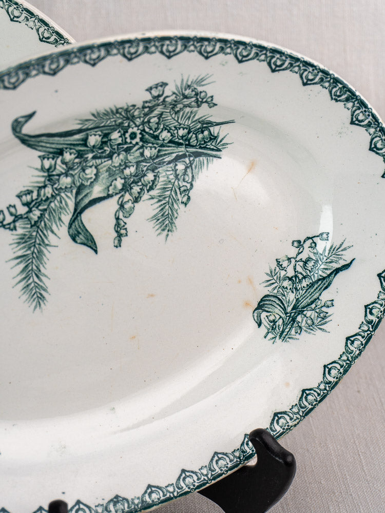 Antique French Saint Amand Muguet faience platter with green floral and ribbon motifs on white ceramic.