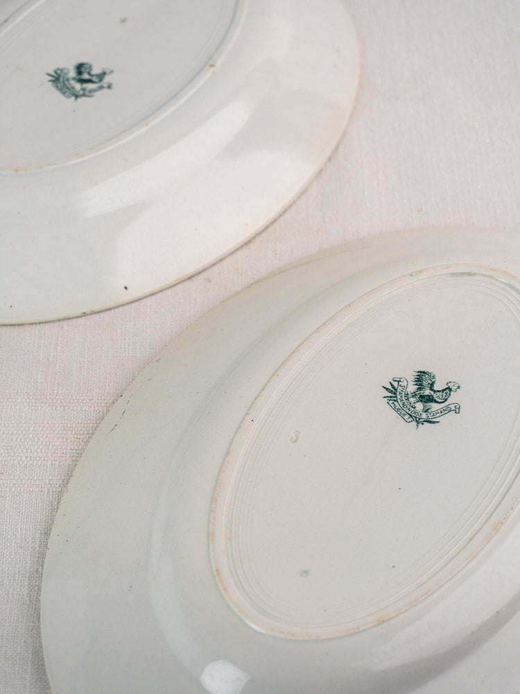Pair of antique Saint Amand oval platters, white faience with green bird stamp, c. 1900.