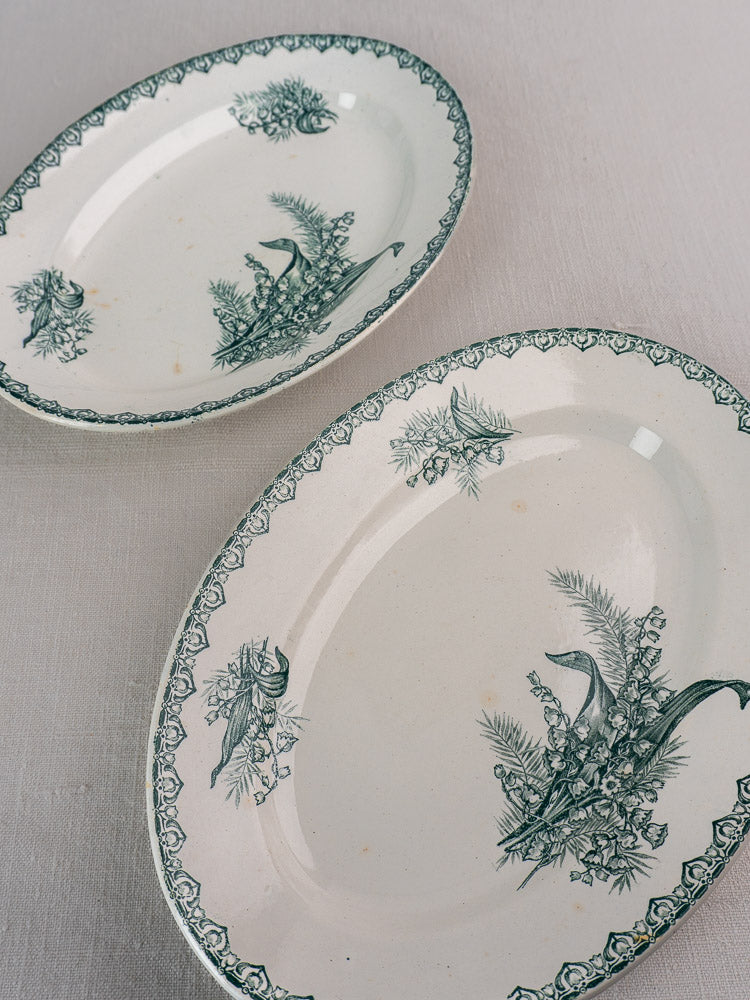 Set of five antique French Saint Amand Muguet faience platters with green floral and fish motifs.