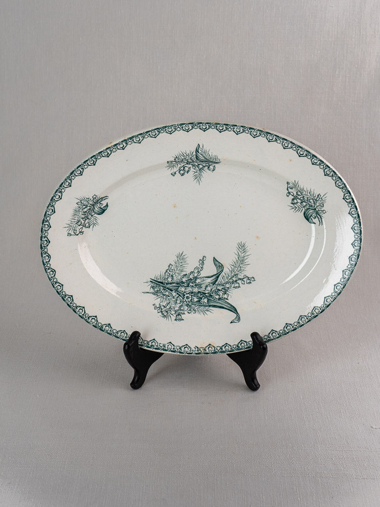 Antique French Saint Amand faience platter set with green Muguet floral design on white ceramic.
