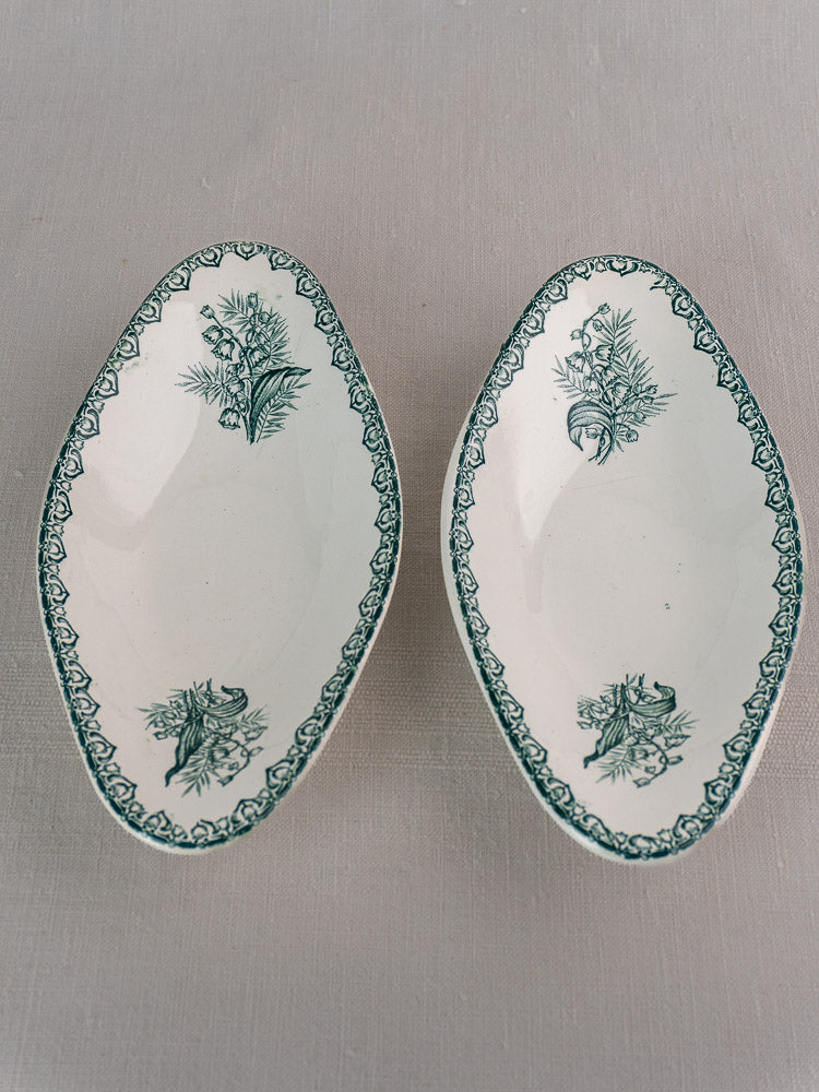Set of five antique French Saint Amand Muguet faience platters with green floral motifs.