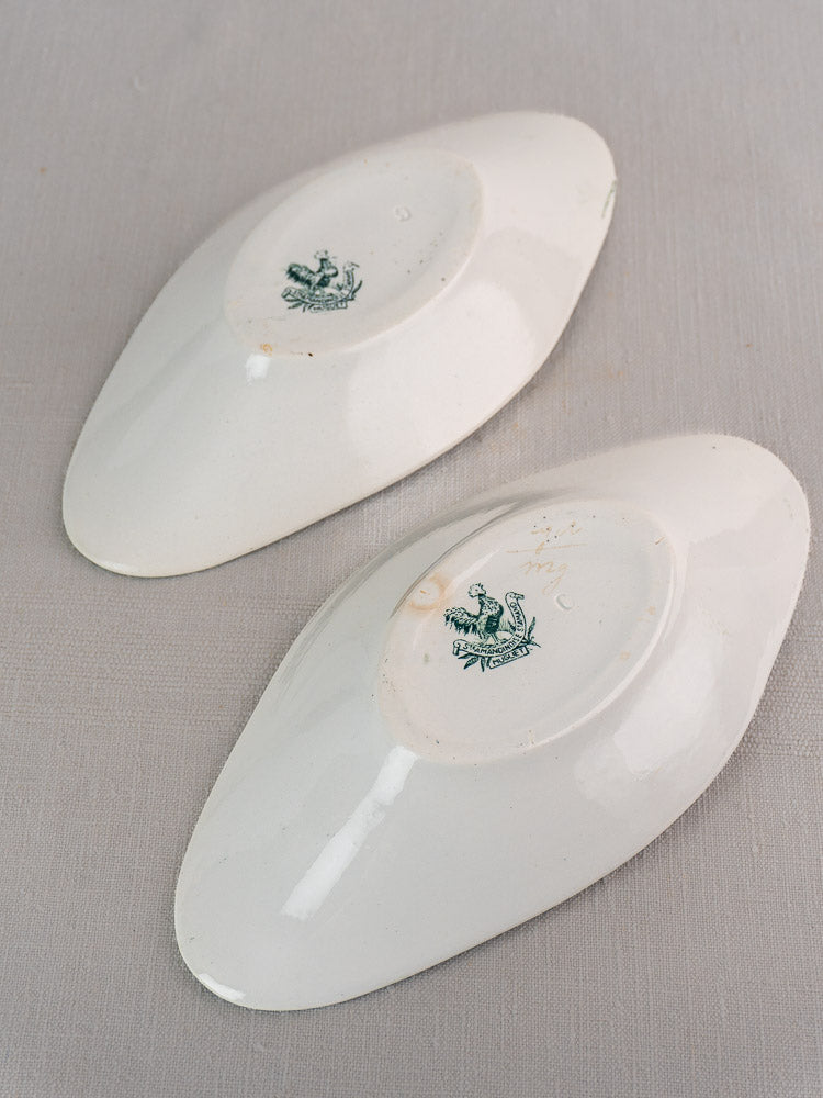 Pair of oval white Saint Amand Muguet ceramic platters, green French maker’s marks visible.