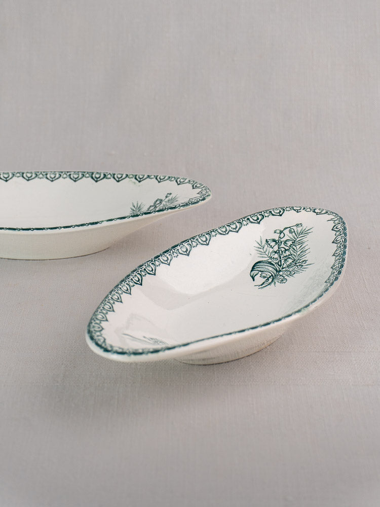 Antique French Saint Amand five-piece faience platter set with green Muguet floral design on white ceramic, displayed on light gray surface.
