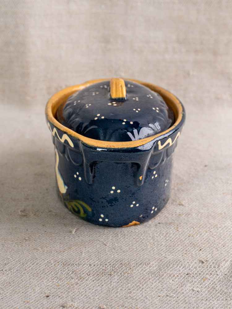 Antique French Soufflenheim covered terrine with cobalt blue glaze, duck motif, yellow accents on beige textured fabric.