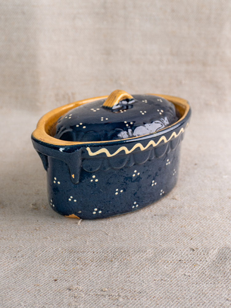 Antique French Soufflenheim covered terrine in cobalt blue with duck motif and yellow accents on beige textured fabric.