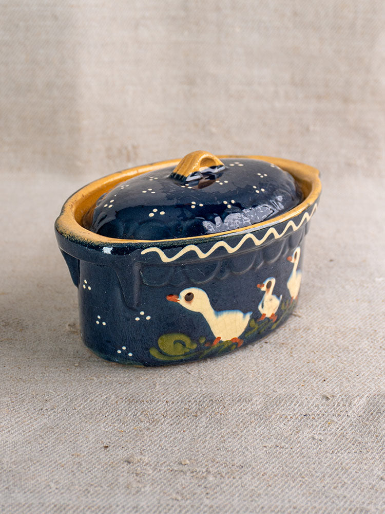 Antique French Soufflenheim cobalt blue covered terrine with duck motif, mid-20th century, on beige fabric surface.