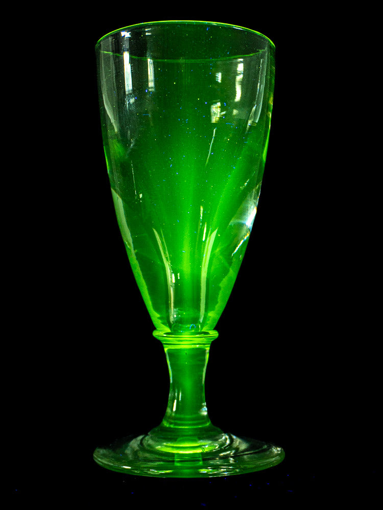 Set of four antique French uranium absinthe glasses, late 19th century, hand-blown ouraline glass on light textured surface.