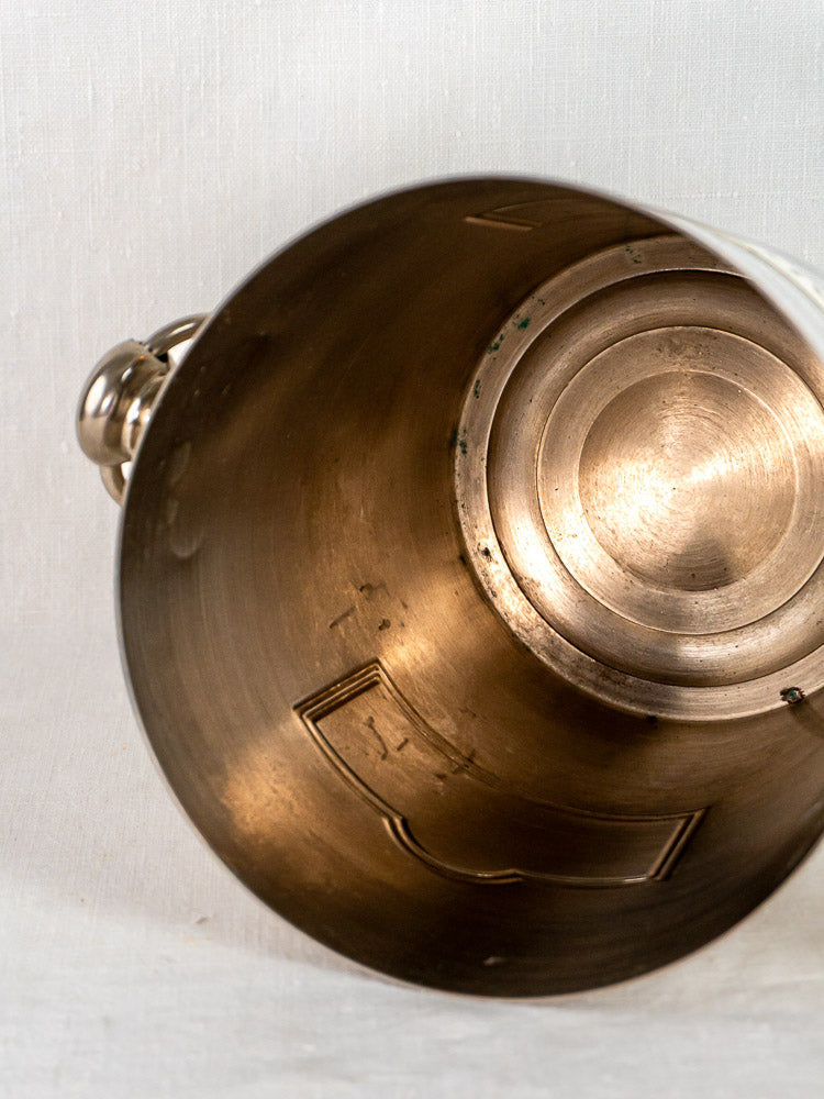 Taittinger vintage French plated champagne bucket with handle, interior visible on white textured surface.