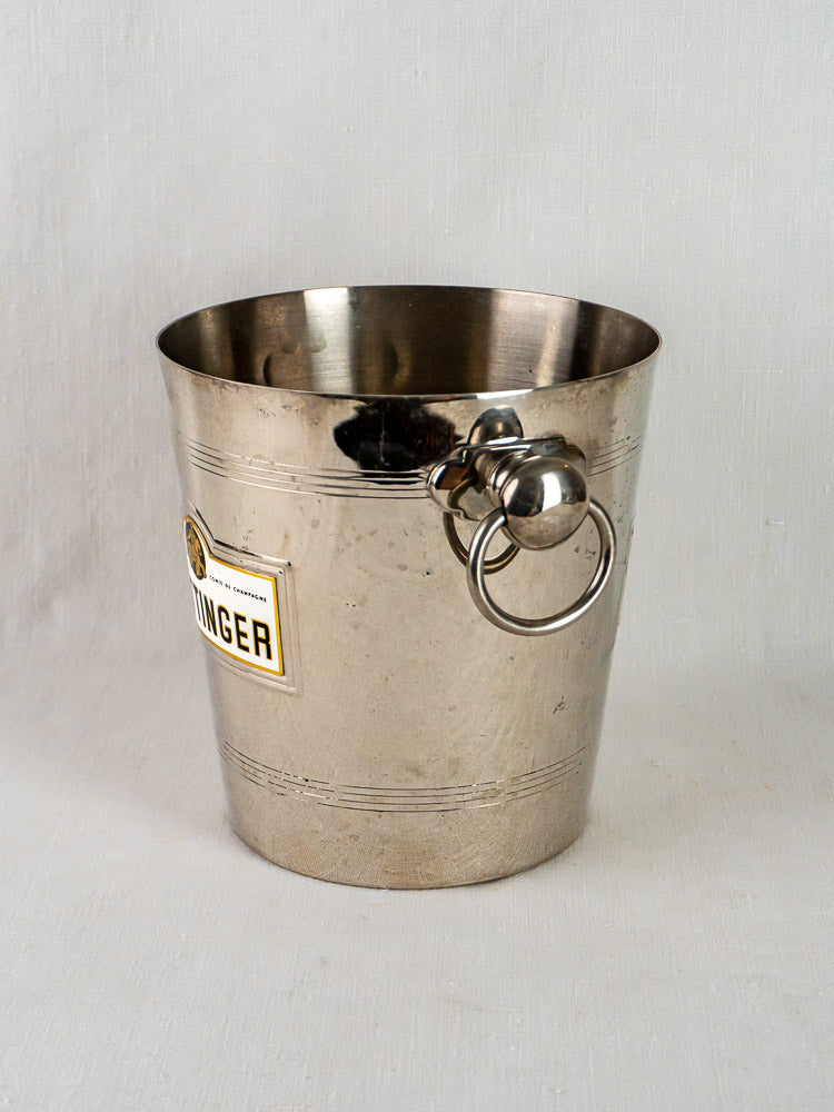 Vintage French Taittinger Champagne bucket with side label and ring handles on a neutral background.