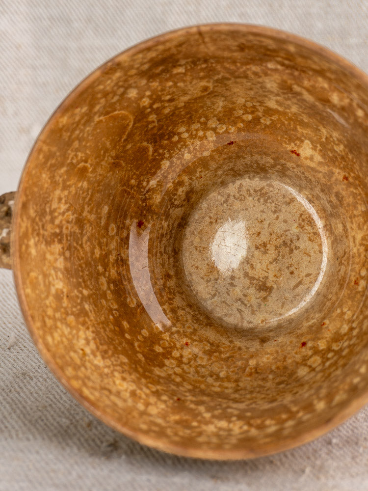 Antique French faience bowl by HB et Cie Choisy-le-Roi with interior staining and brown ring on light fabric background.