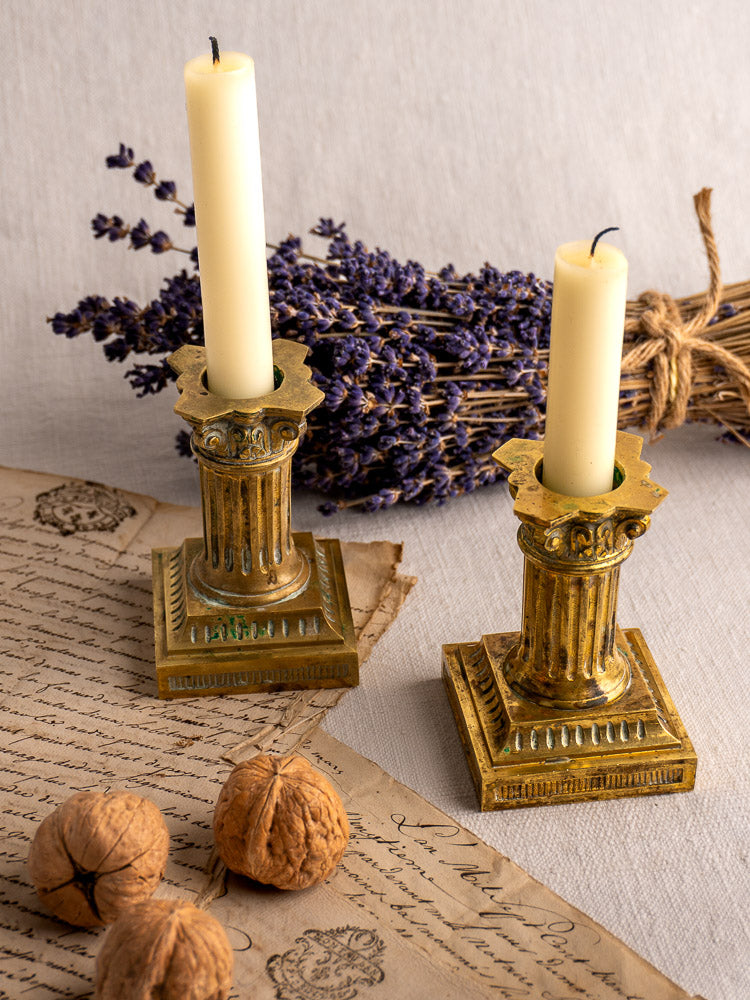 Antique French Louis XVI gilded brass candlesticks with lit ivory candles on handwritten letters, walnuts, and dried lavender.