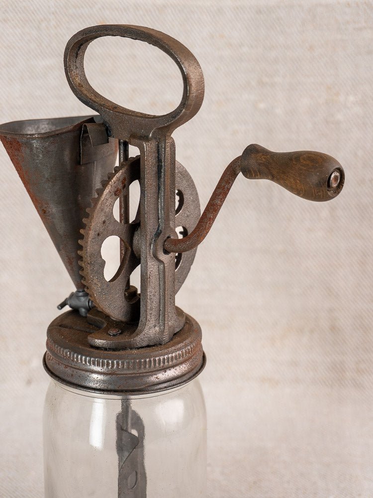 Antique French mayonnaise maker, circa 1900, with cast iron hand crank on glass jar lid.