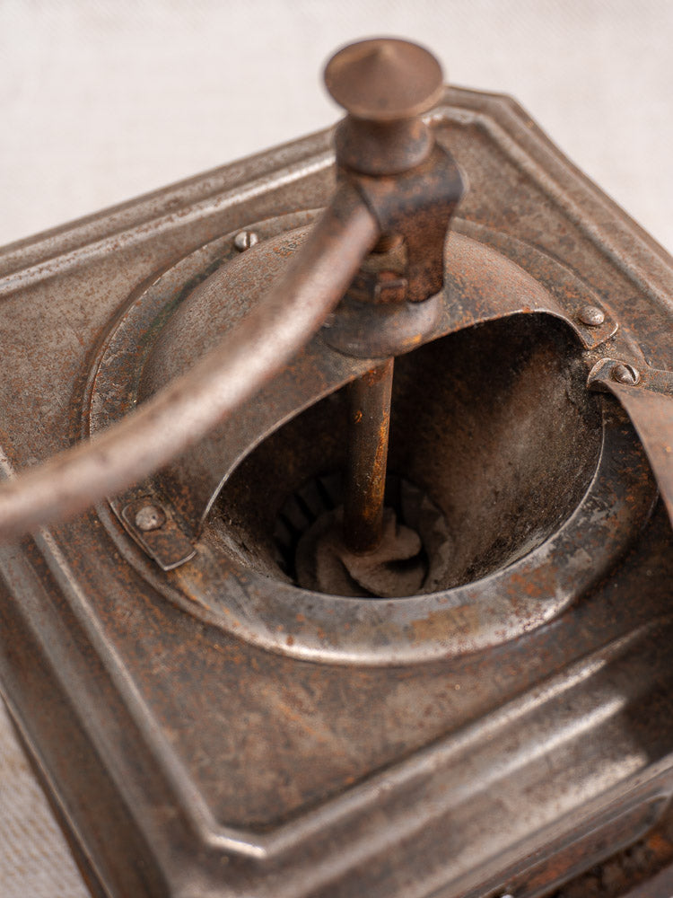 Antique French Peugeot Frères coffee mill in tinned steel with exposed grinding mechanism and metal handle.