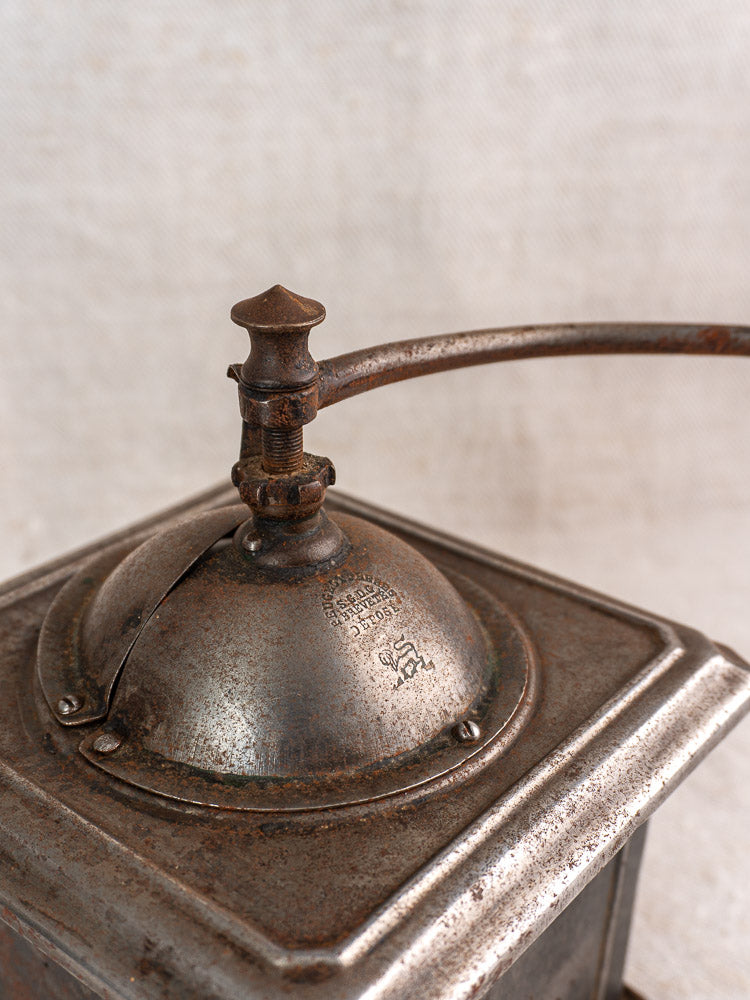 Antique French Peugeot Frères tinned steel coffee mill with curved handle and aged patina.