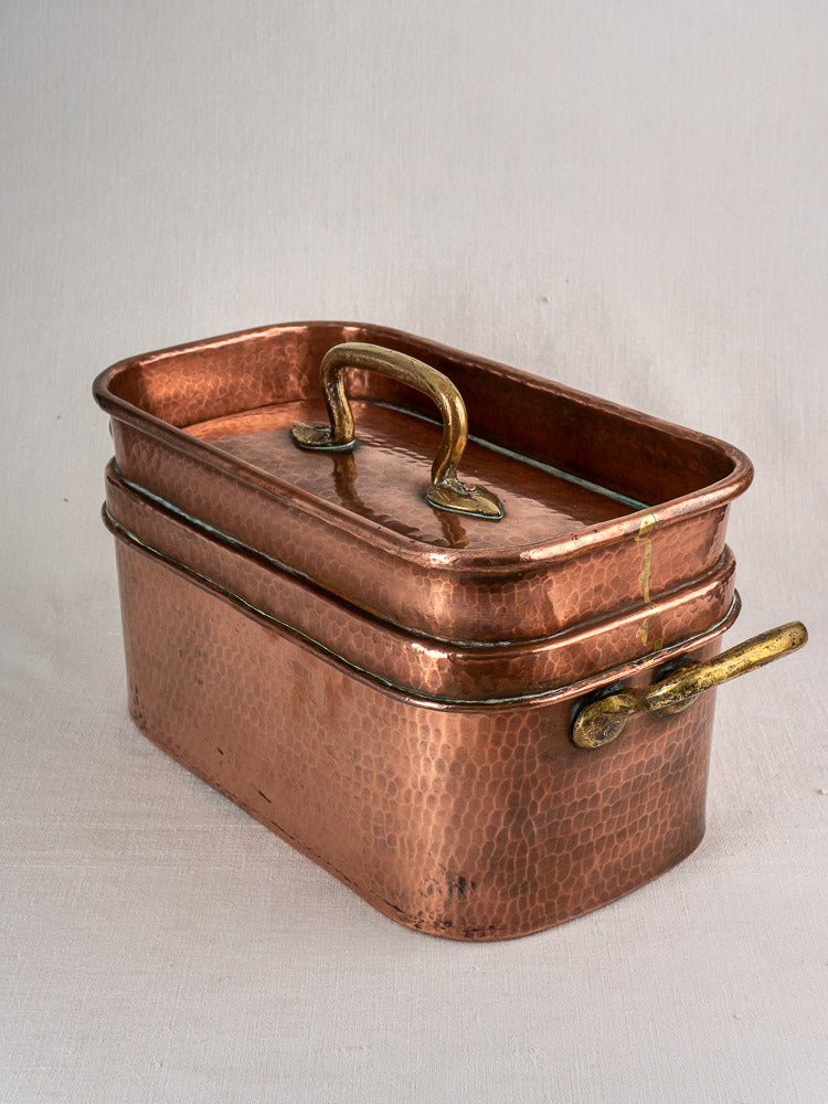 Large 19th-century antique French copper daubière with brass handles and aged patina on a neutral background.