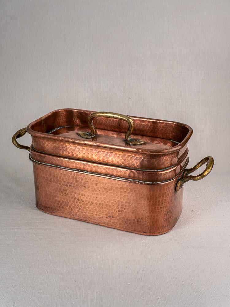Large 19th-century French copper daubière, hand-hammered with fitted lid and three brass handles, on neutral background.