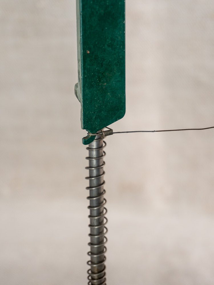 Close-up of a 1960s green French Roquefort cheese cutter by Maria Grimal, metal spring and wire detail.