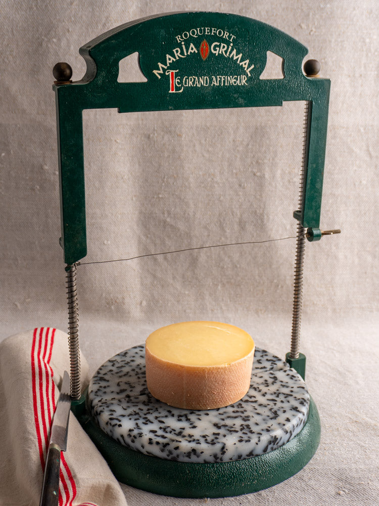 Vintage French Roquefort Cheese Cutter by Maria Grimal Fromagerie, 1960s, on marble base with knife and striped cloth.