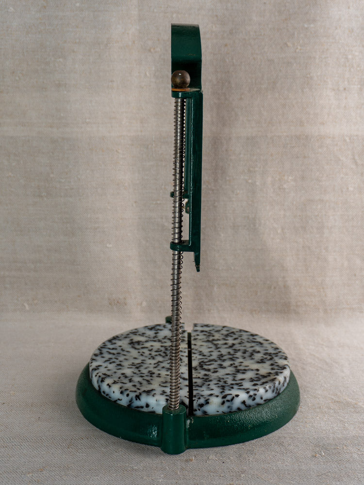 Vintage French Roquefort cheese cutter, Maria Grimal, 1960s, green metal handle, speckled stone base on beige fabric.
