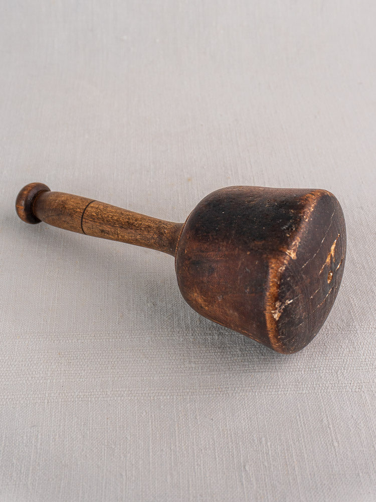 Set of three antique French turned hardwood mallets with aged patina, displayed on a light gray textured surface.