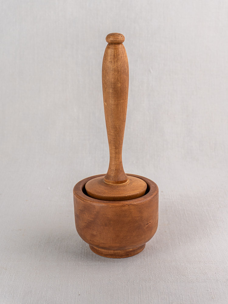 Antique French wooden mortar and pestle, turned hardwood, early-mid 20th century, on light gray background.