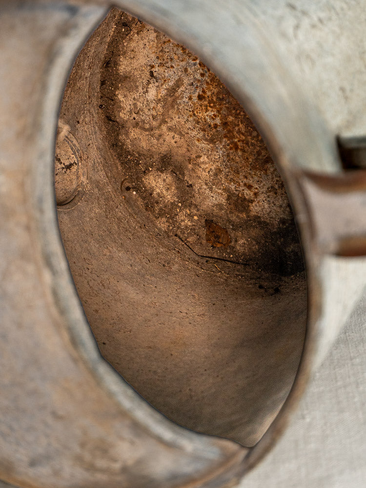 Interior of French zinc arrosoir with aged, rusted metal and richly textured patina.