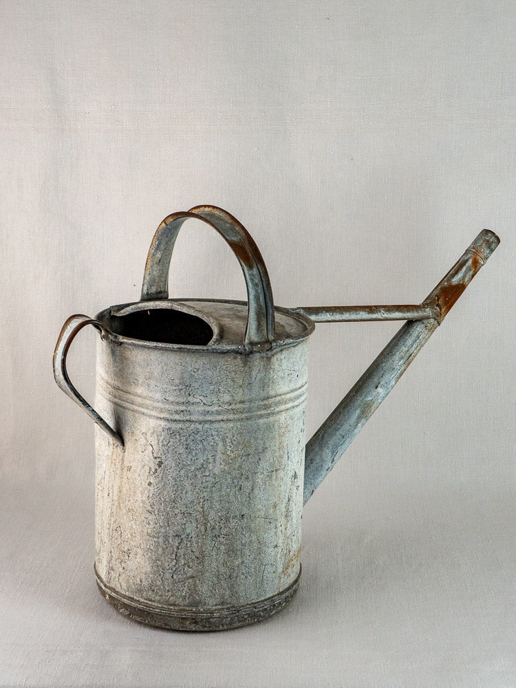 Vintage French zinc watering can with large handle, long spout, and charming weathered patina.