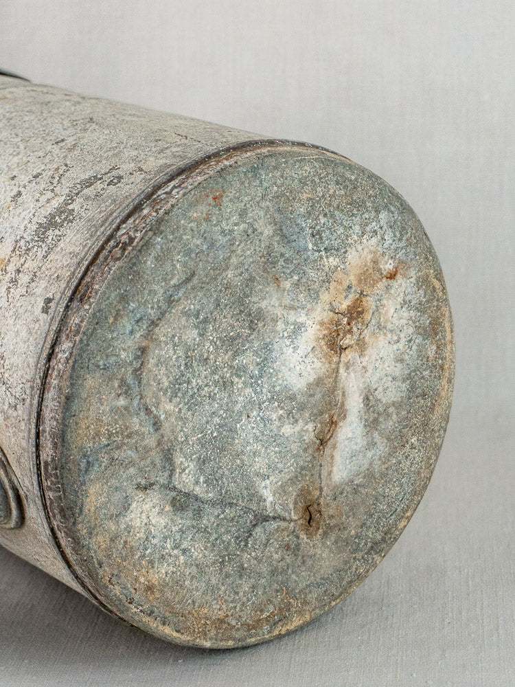 French zinc garden watering can bottom showing aged metal with rust, scratches, and discoloration.